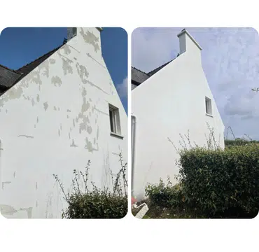 Ravalement de façade d'un pignon derrière une haie, enduit rénové en blanc