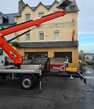 Ravalement de façade d'un commerce, enduit ancien avant travaux avec nacelle