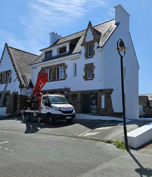 Ravalement de façade d'une maison en cours de rénovation avec camion nacelle