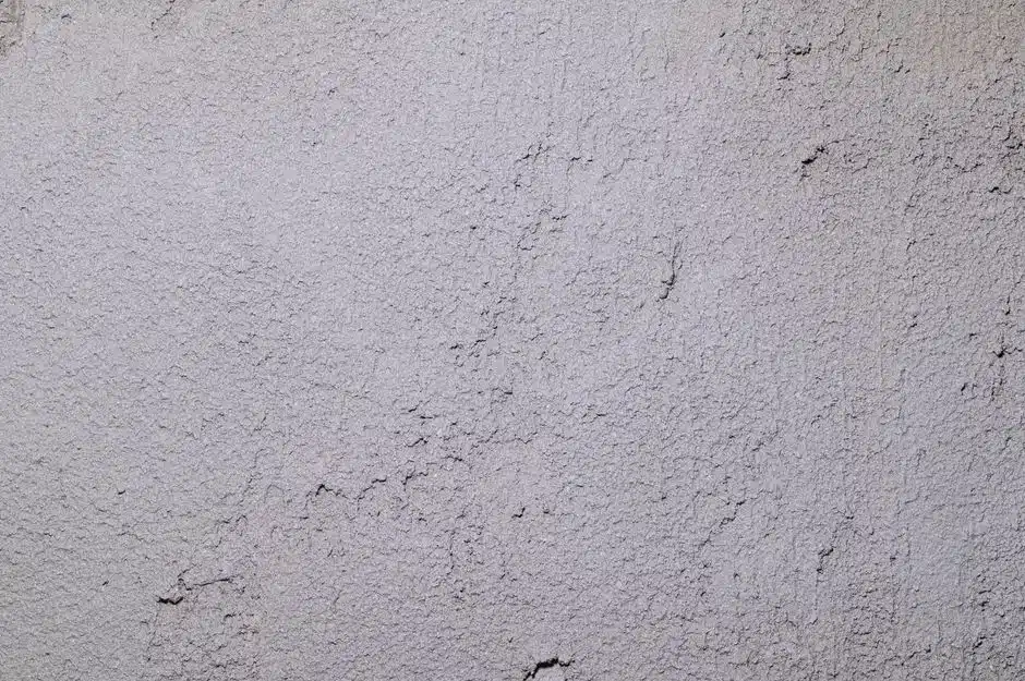 Surface d'enduit gris clair finement grenée